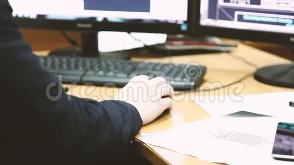 男人用两台显示器在电脑上工作视频的预览图