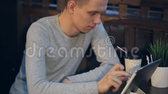 带着平板电脑的年轻人在咖啡厅喝咖啡视频的预览图
