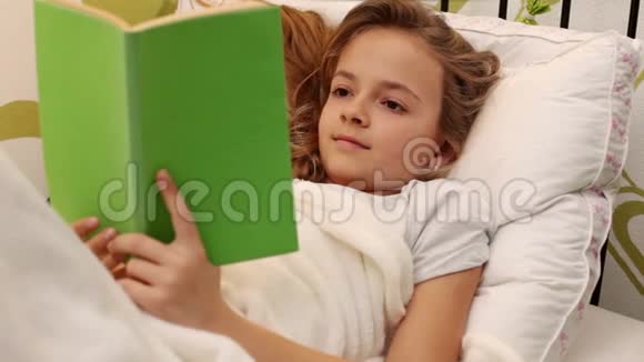 年轻女孩躺在床上看书视频的预览图