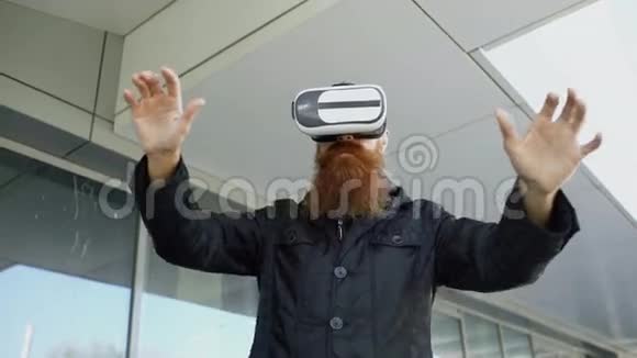 年轻的大胡子男子使用虚拟现实耳机360虚拟现实体验步行在城市街道户外视频的预览图