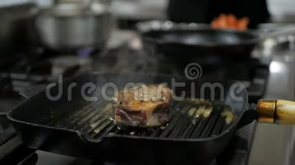 厨师在餐厅厨房的烤盘里煮牛肉牛排视频的预览图