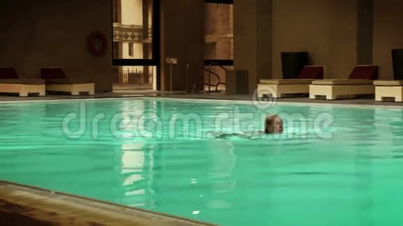 小女孩在一家大旅馆的室内游泳池里游泳视频的预览图