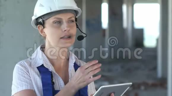 女建筑工程师通过内部联系阅读计划并与工人交谈视频的预览图