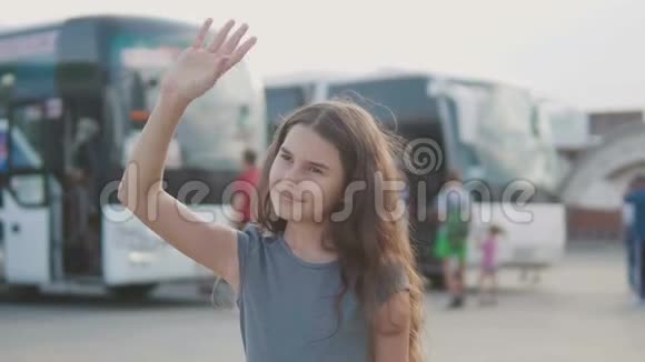 小女孩挥手在汽车站慢动作视频离开告别少女告别少女说视频的预览图
