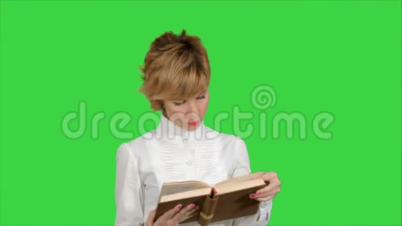 年轻的商务女性集中精力在绿色屏幕上拿着书读着书彩色钥匙视频的预览图