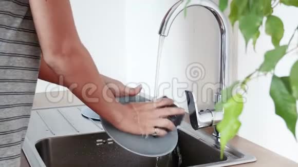 女人在厨房水槽里洗盘子视频的预览图