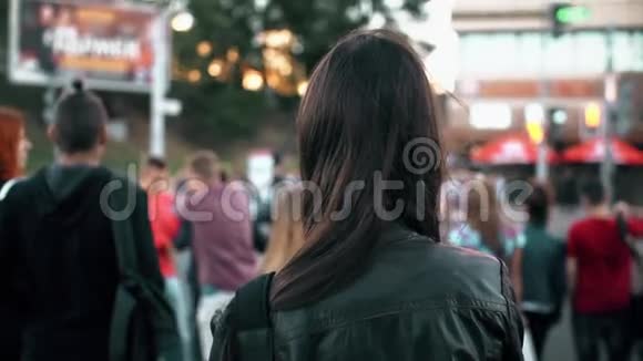 年轻女子站在街上在红绿灯处准备十字路头发随风飘扬后景慢节奏视频的预览图