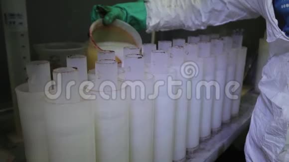 一排排塑料滤水器正由工人用白色液体填充视频的预览图