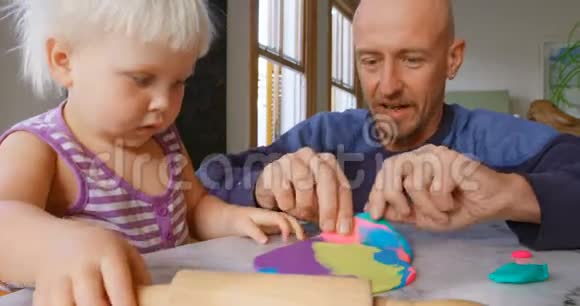 父亲和女儿在舒适的家里和粘土一起玩耍视频的预览图