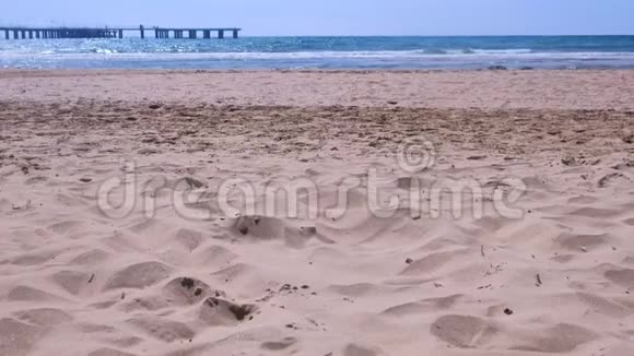 在风和日丽的日子里海沙滩有暴风雨的海浪和码头景观视频的预览图