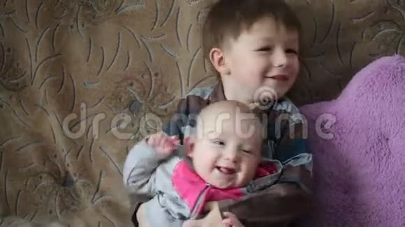 小男孩牵着她微笑的姐妹视频的预览图