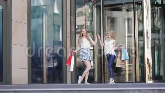 快乐的女人带着袋子从购物中心出来视频的预览图