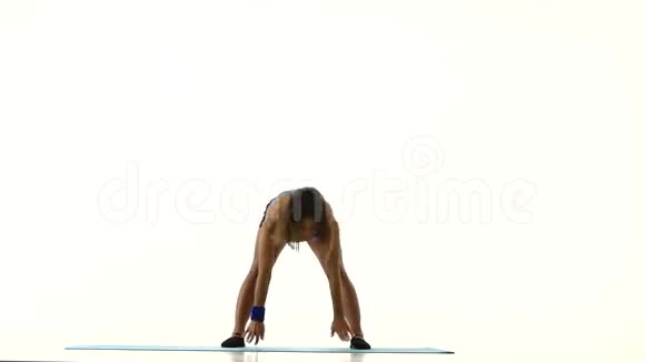 体操运动员站在她的头上改变腿的姿势白色视频的预览图