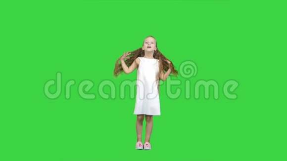 跳舞的金发小女孩在绿色屏幕上唱歌Chroma键视频的预览图