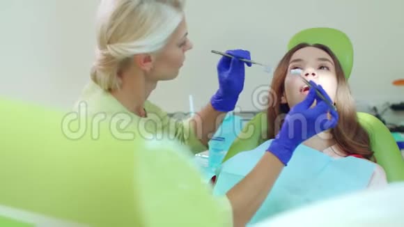 在现代牙科诊所与病人合作的医生女牙医视频的预览图