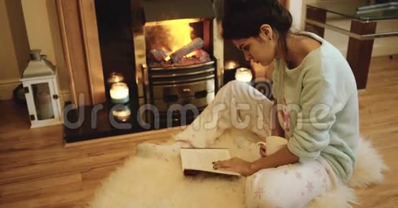 可爱的少女正在壁炉旁看书红色史诗4k视频的预览图