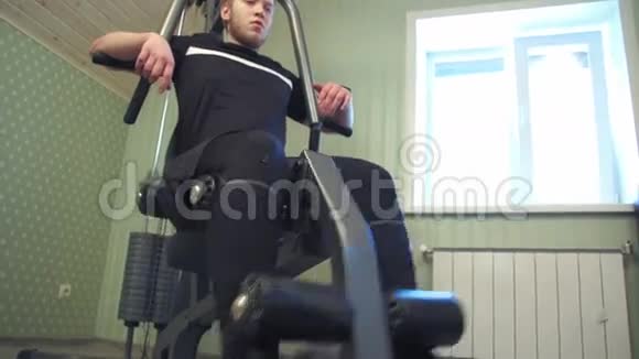 年轻人在家里健身器材上锻炼腿部肌肉视频的预览图
