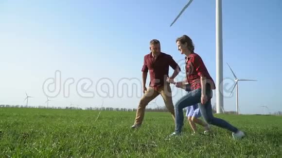 一个男人带着一个女人在绿色的草地上带着孩子走动作很慢视频的预览图