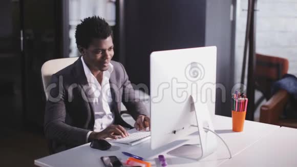现代办公室里的非裔美国人键盘打字视频的预览图