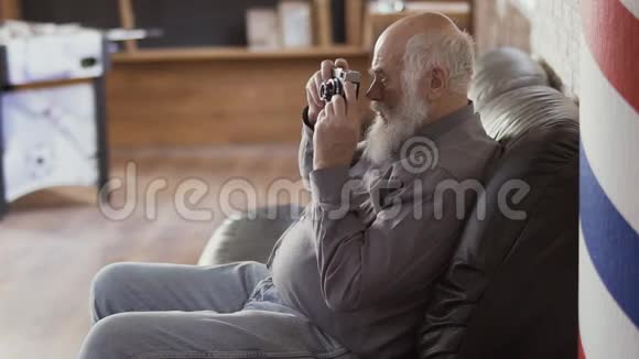 英俊的成熟男人用旧相机拍照视频的预览图