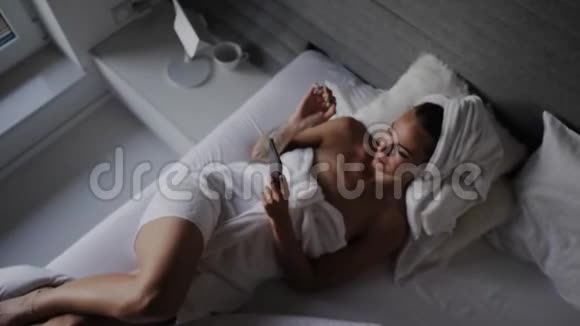 躺在床上拿着手机的女人视频的预览图