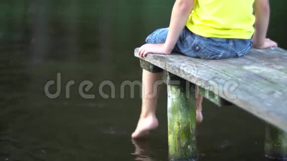 坐在游泳池桥上的男孩视频的预览图
