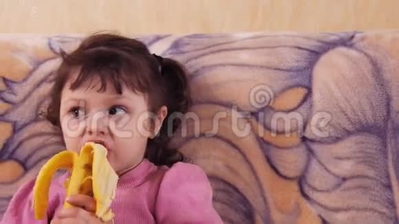 小女孩吃香蕉津津有味地吃着香蕉视频的预览图