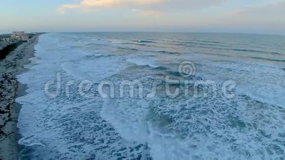 温暖的日落日出在平静的白色泡沫波佛罗里达大西洋可可海滩海岸线4k空中无人机视频的预览图