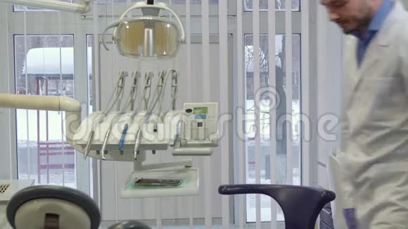 牙医坐在他办公室的椅子上视频的预览图