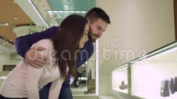 一对夫妇在商店里用珠宝看购物陈列视频的预览图