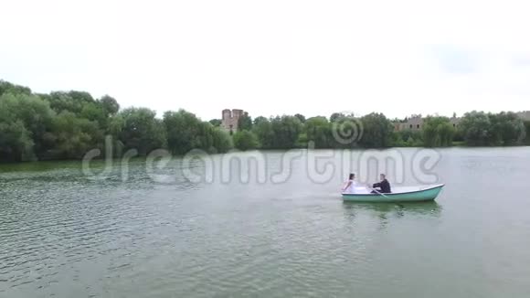 新婚夫妇在池塘上划船视频的预览图