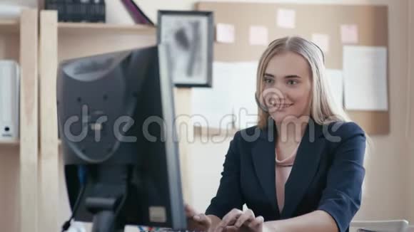 呼叫中心员工在办公室工作一个年轻的女孩坐在办公室的电脑前女孩接到电话视频的预览图