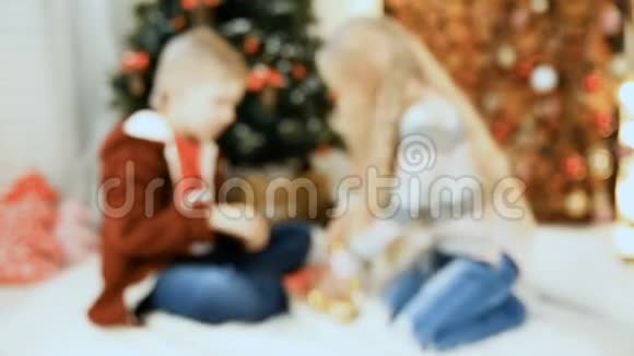 在圣诞树附近摆姿势的男孩和女孩视频的预览图