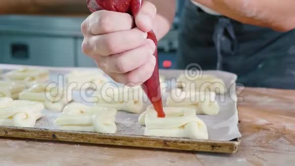 专业面包师在放入烤箱前将果酱加入甜烤炉上视频的预览图