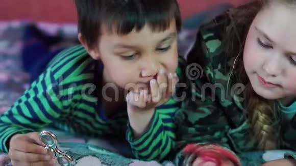 多民族的小男孩和女孩在沙发上玩旋转者视频的预览图