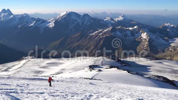 孤独的登山者在冰爪上来到高加索山脉的埃尔布鲁斯峰顶雪峰视频的预览图