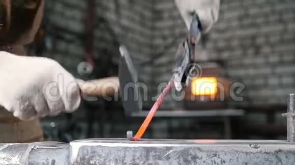 铁匠是用铁锤弯曲铁棒的金属车间关闭视频的预览图