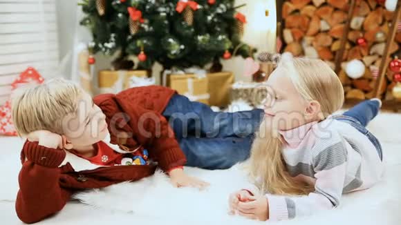 在圣诞树附近摆姿势的男孩和女孩视频的预览图