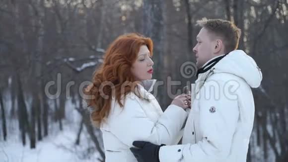 一对夫妇站在白雪覆盖的森林里视频的预览图