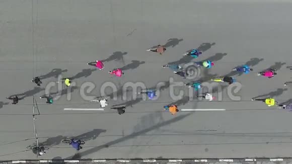 在城市道路上跑马拉松的人群的空中镜头视频的预览图