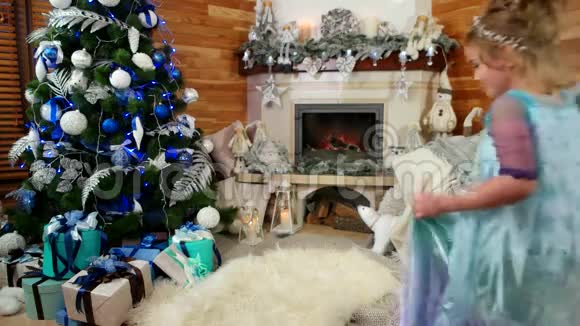 圣诞前夜圣诞树下的礼物女孩带了一份礼物新年的惊喜一个快乐孩子视频的预览图