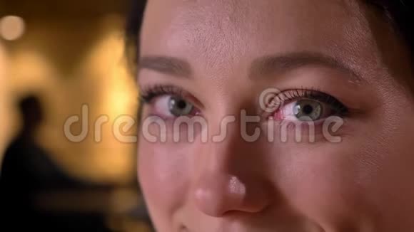一张年轻的白种人女性脸蓝色的眼睛直视着镜头带着微笑的面部表情视频的预览图