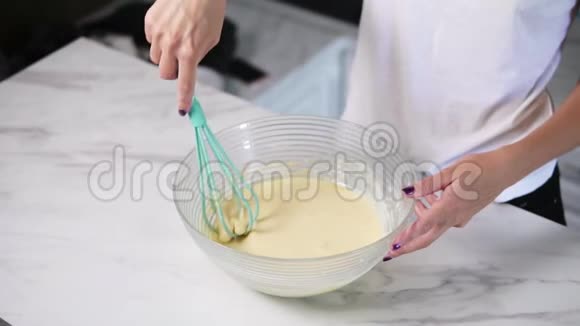 无法辨认的女人在碗里用搅拌器混合配料自制烹饪慢镜头视频的预览图