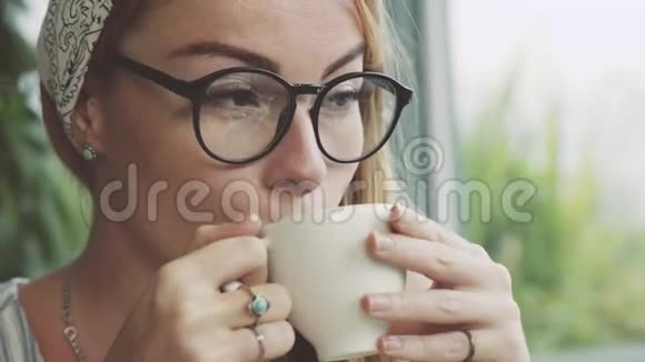 美丽的年轻女子在舒适的咖啡馆喝咖啡女孩休息一下视频的预览图