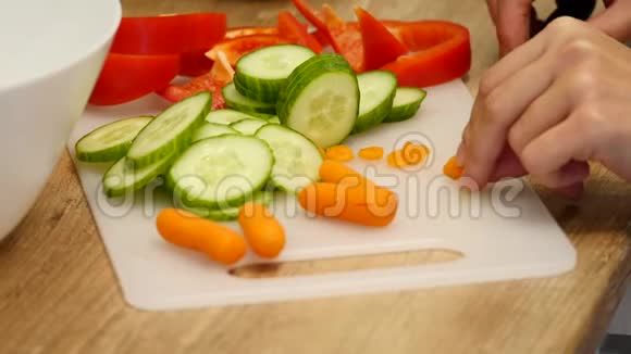 正上方的妇女切胡萝卜的木板在柜台上放着一些新鲜蔬菜视频的预览图