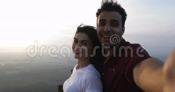 山顶情侣在日出时自拍拉丁男女开心的笑着视频的预览图