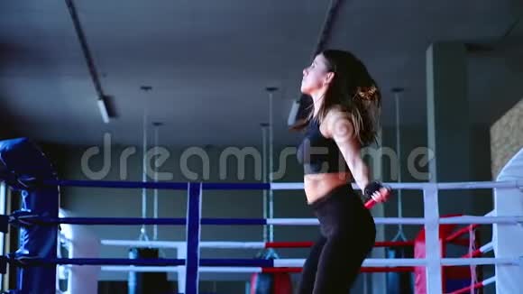 动作慢特写迷人可爱的苗条黑发女子运动员在健身房跳绳训练拳击视频的预览图