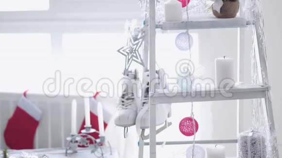 时尚的白色圣诞内部装饰阶梯袜子蜡烛花环冬季溜冰鞋靠窗户慢慢慢慢视频的预览图