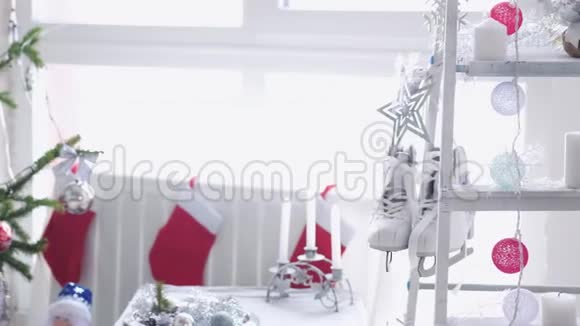 时尚的白色圣诞内部装饰杉树袜子蜡烛花环冬季溜冰鞋靠窗户慢慢慢慢视频的预览图