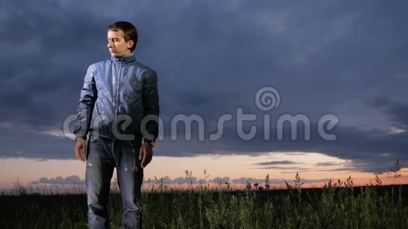 一个可爱的年轻人在田野的日落时挥动蚊子背景上美丽的天空视频的预览图